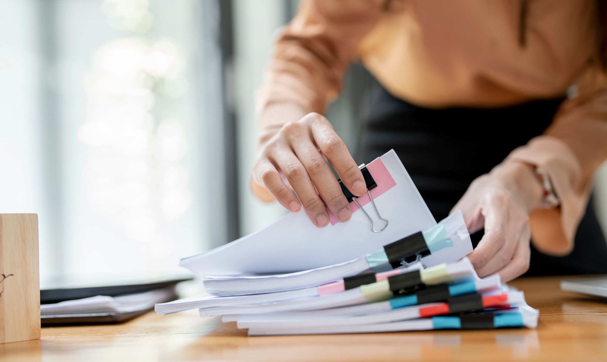 A woman looking through a stack of papers.